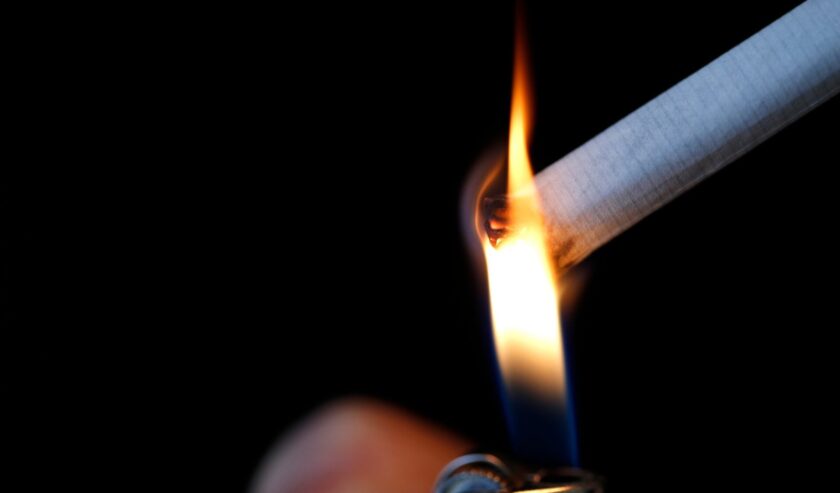 Ilustrasi seseorang yang tengah menyalakan rokok dengan korek api. Foto: Reuters