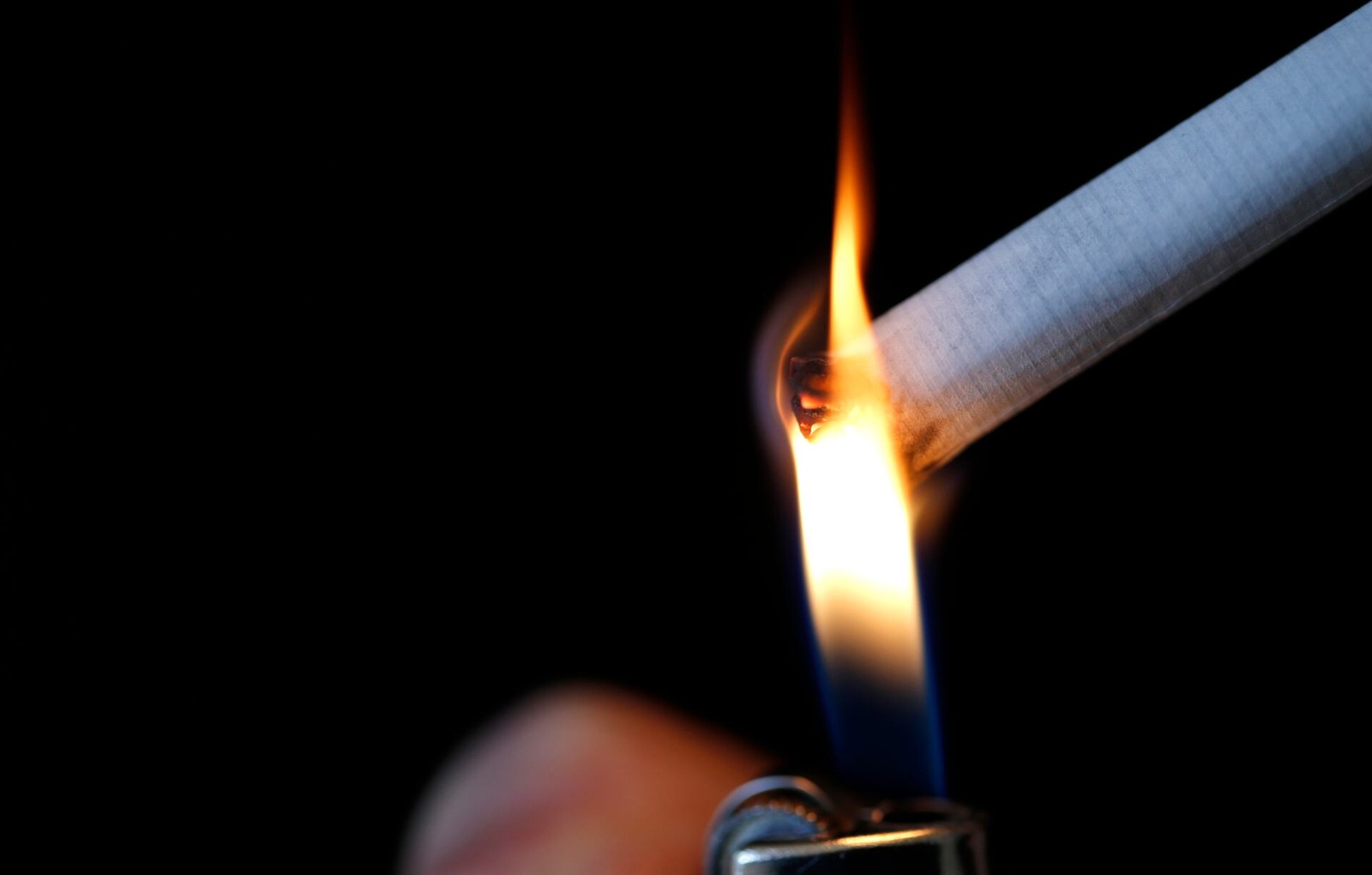 Ilustrasi seseorang yang tengah menyalakan rokok dengan korek api. Foto: Reuters