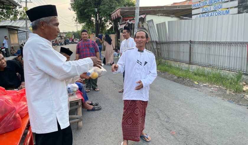 Pembagian takjil dan nasi bungkus kepada masyarakat dalam acara rutin buka bersama satu dusun di Dusun Telapak, Radegan Sari, Driyorejo, Minggu (24/3/2024). Foto: Firman Magang suarasurabaya.net