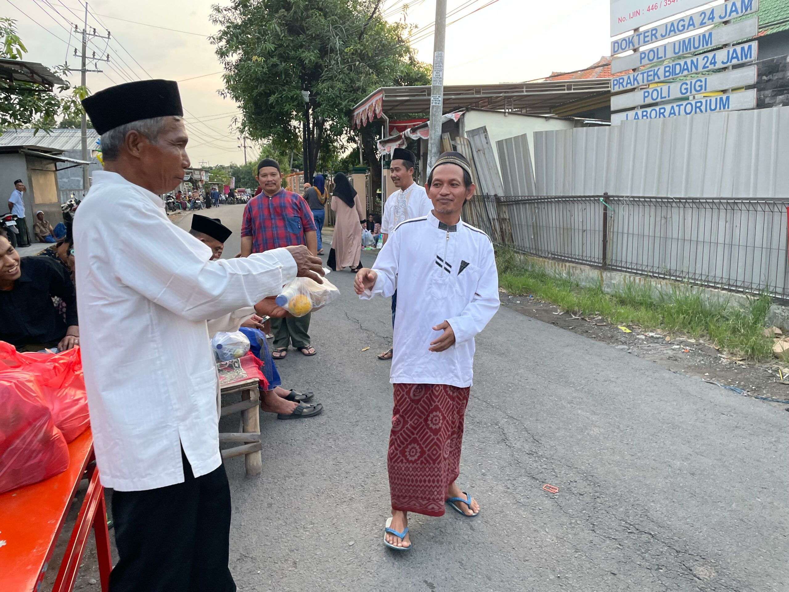 Pembagian takjil dan nasi bungkus kepada masyarakat dalam acara rutin buka bersama satu dusun di Dusun Telapak, Radegan Sari, Driyorejo, Minggu (24/3/2024). Foto: Firman Magang suarasurabaya.net