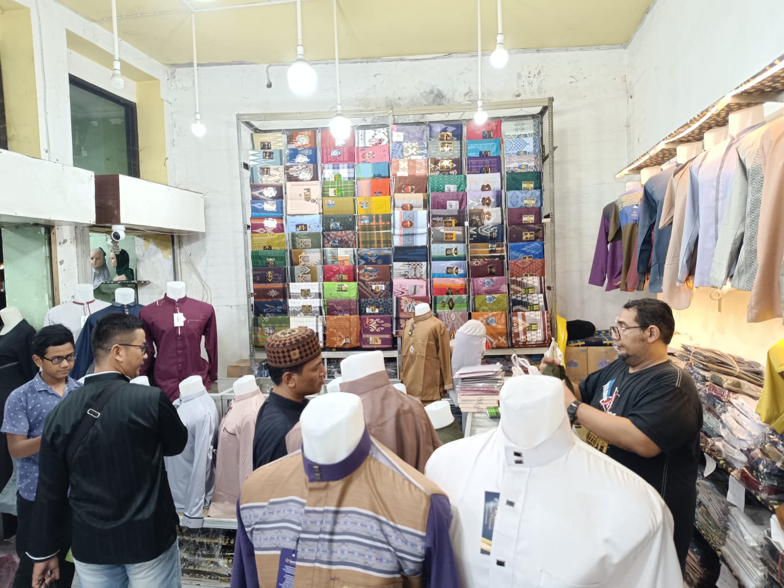 Pembeli saat mencari baju di salah satu toko di pasar ampel Surabaya, Minggu (24/3/2024). Foto: Risky suarasurabaya.net