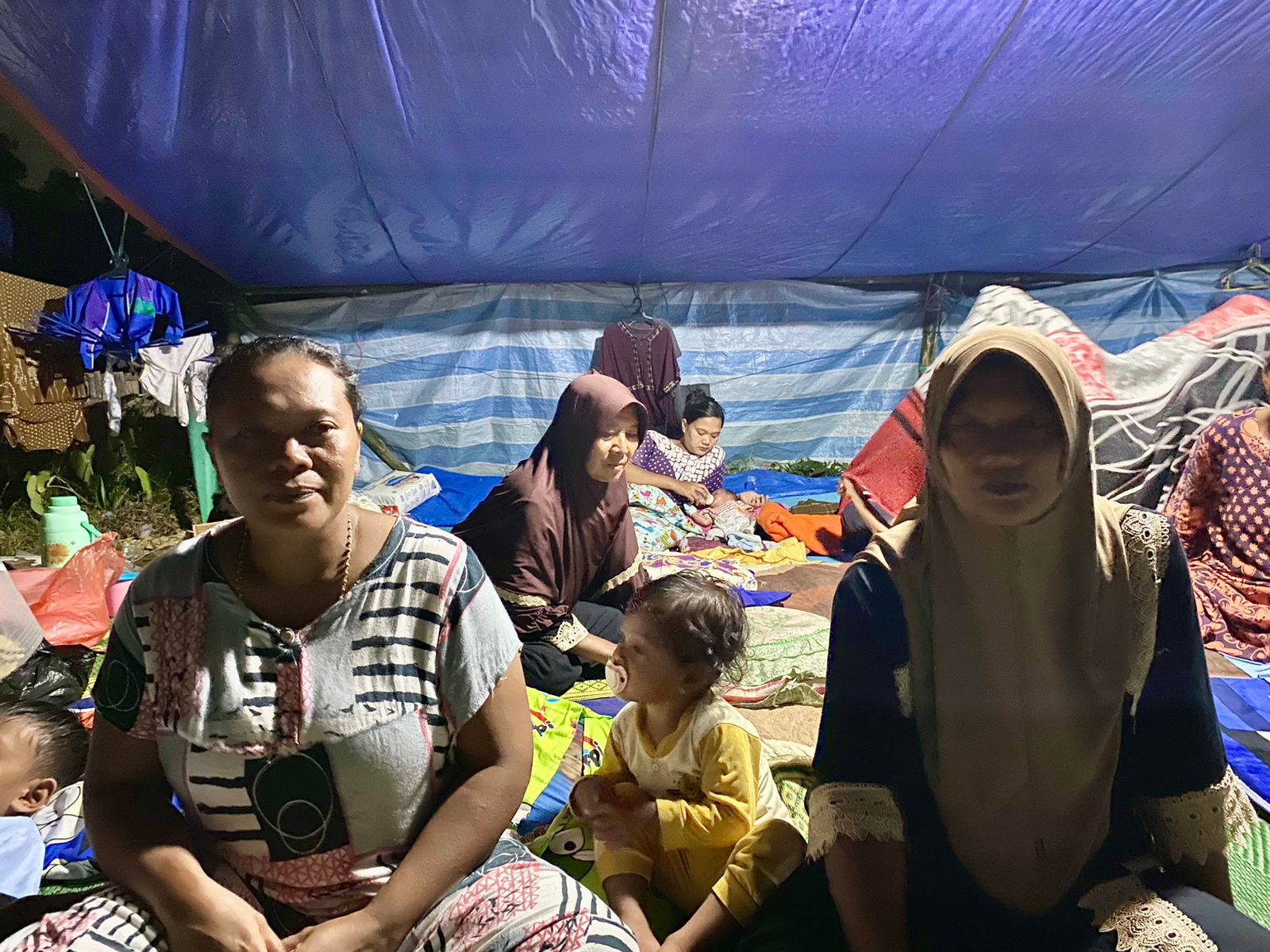 Muslifa dan Musliha (kanan-kiri) satu keluarga yang mengungsi di tenda areal persawahan Desa Dekatagung, Kecamatan Sangkapura, Pulau Bawean, Gresik, Selasa (26/3/2024). Foto: Wildan suarasurabaya.net