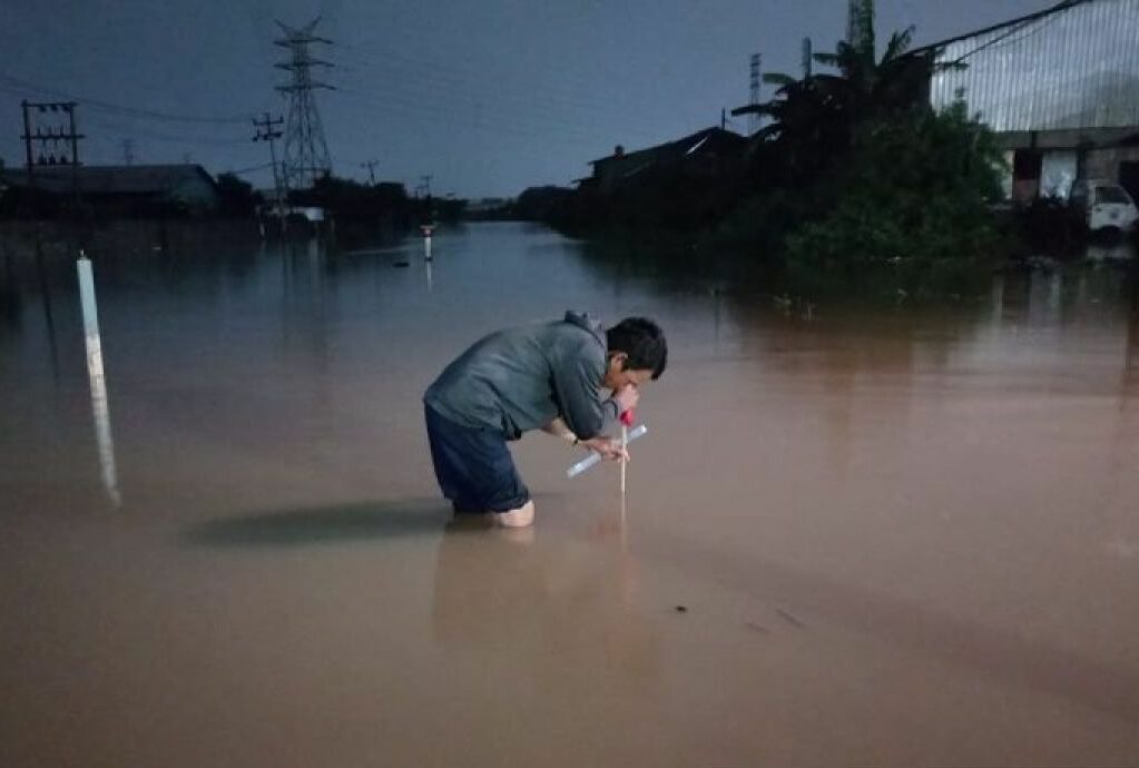 Petugas mengukur ketinggian banjir di jalur rel kereta api di wilayah Daop 4 Semarang, sehingga tidak bisa dilalui pada Kamis (14/3/2024). Foto: Humas KAI