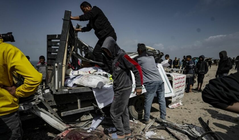 Warga Palestina mengeluarkan puing-puing kendaraan bantuan kemanusiaan yang rusak berat, yang menjadi sasaran serangan udara Israel yang mengakibatkan sembilan orang tewas dan puluhan lainnya luka-luka, di Deir al-Balah, Gaza, Palestina, Minggu (3/3/2024). Foto: Anadolu
