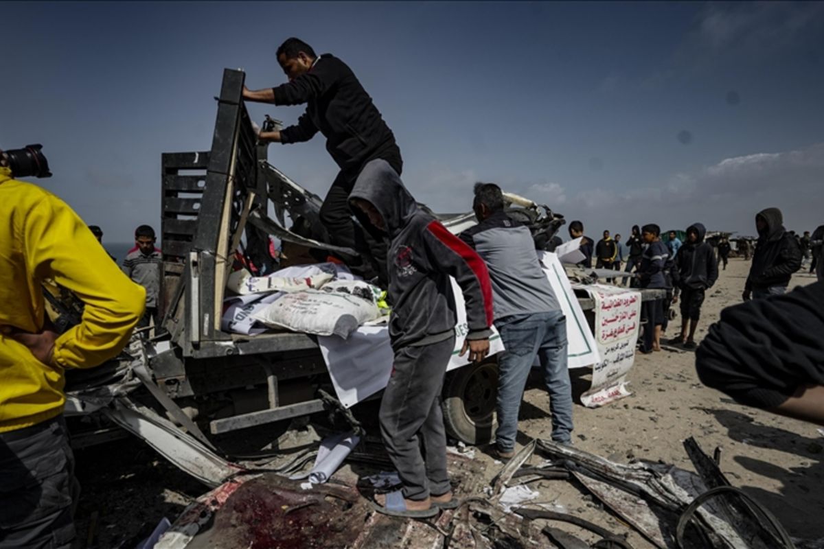 Warga Palestina mengeluarkan puing-puing kendaraan bantuan kemanusiaan yang rusak berat, yang menjadi sasaran serangan udara Israel yang mengakibatkan sembilan orang tewas dan puluhan lainnya luka-luka, di Deir al-Balah, Gaza, Palestina, Minggu (3/3/2024). Foto: Anadolu
