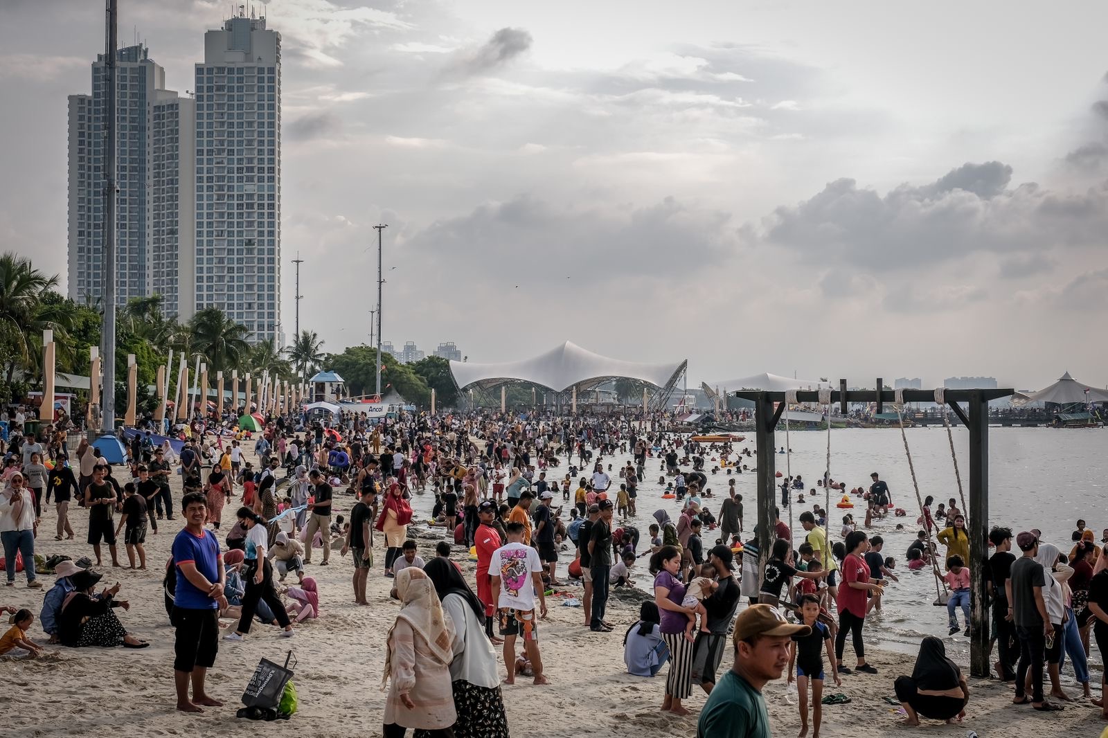 Ilustrasi - Masyarakat berwisata di pantai.