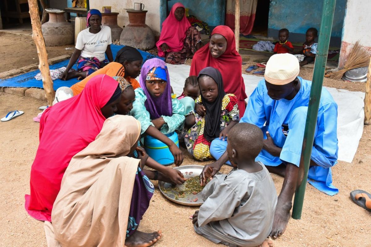 Sebuah keluarga menikmati millet couscous dengan saus okra bersama-sama di Kerawa, wilayah Far North, Kamerun, 7 Agustus 2023.