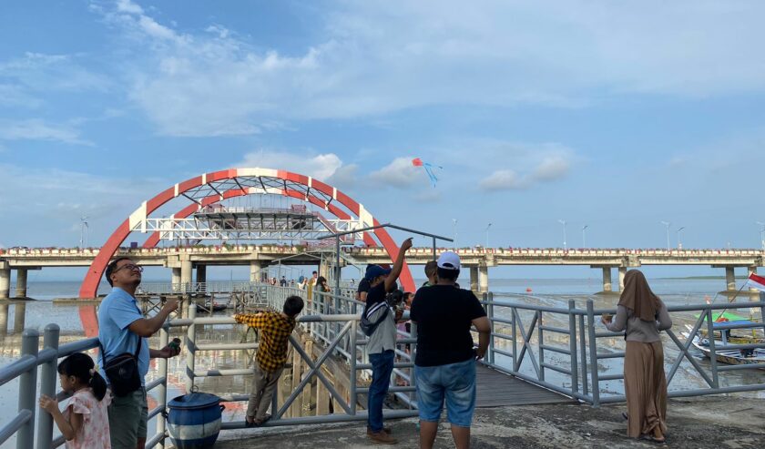 Suasana pengunjung berada di jembatan wisata THP Kenjeran sedang menikmati suasana pantai, Kamis (11/4/2024). Foto: Wildan suarasurabaya.net