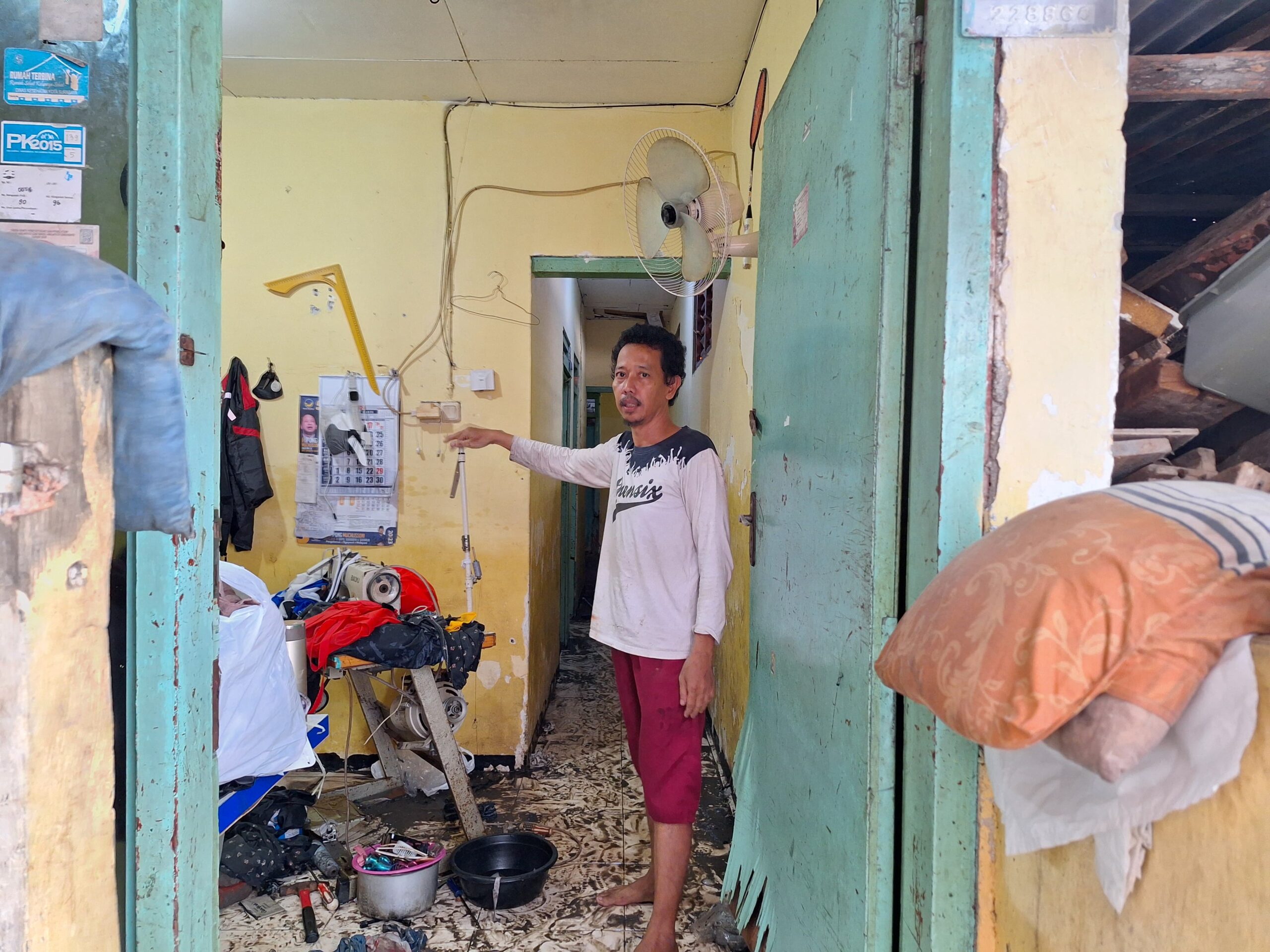 Riyanto salah satu warga Dukuh Kupang yang rumahnya terdampak banjir seleher orang dewasa, Jumat (5/4/2024). Foto: Meilita suarasurabaya.net