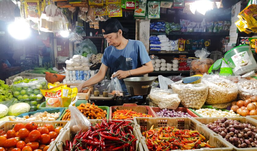 Pedagang bahan kebutuhan pokok di Pasar Wonokromo Kota Surabaya, saat akan menimbang telur, Minggu (7/4/2024). Foto: Ikke magang suarasurabaya.net