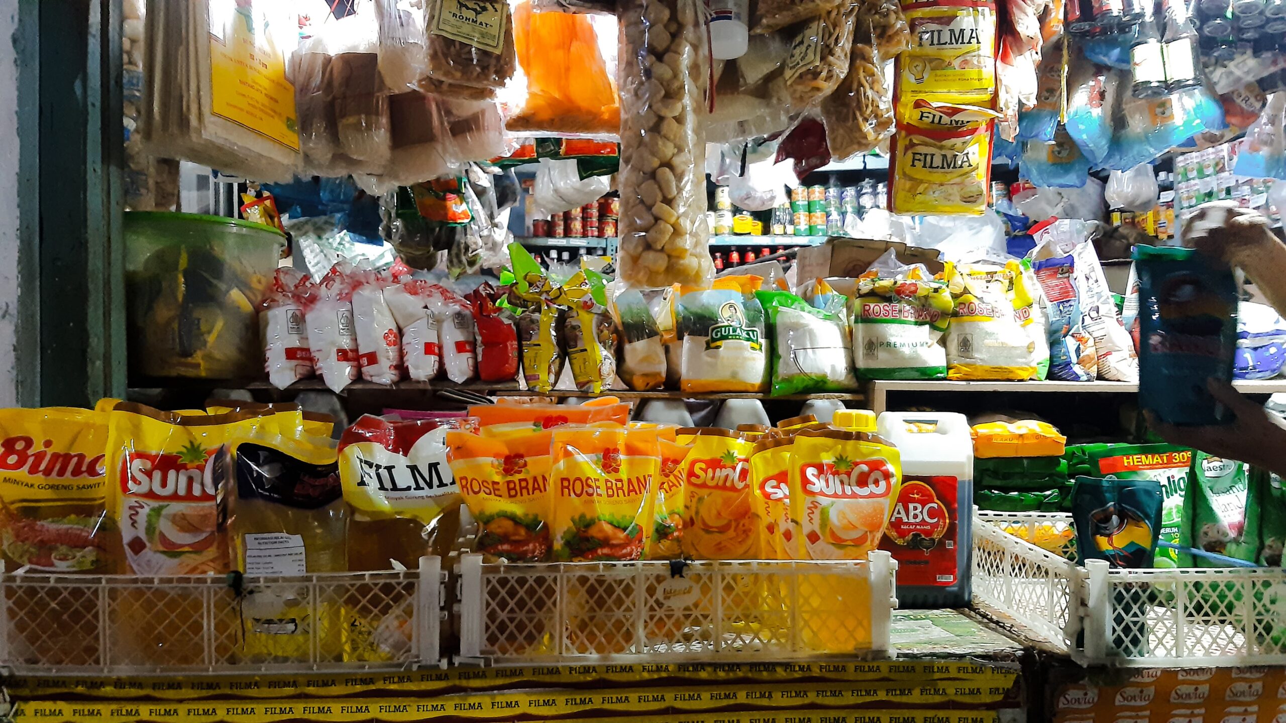 Sejumlah minyak goreng, gula dan bahan kebutuhan pokok lain yang terpajang di salah satu stan pedagang di Pasar Pucang Anom Kota Surabaya, Minggu (7/4/2024). Foto: Ikke magang suarasurabaya.net