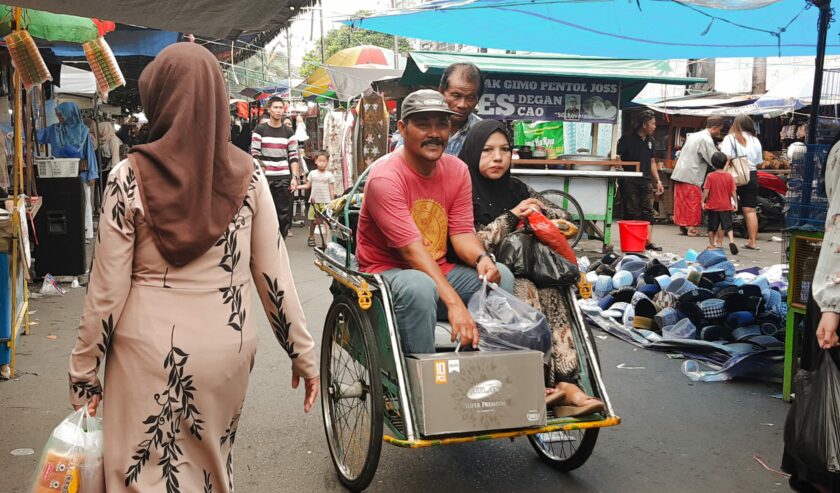 Pengunjung naik becak usai berbelanja dalam event Pasar Bandeng Kawak 2024 di Jalan Samanhudi, Gresik pada Senin (8/4/2024). Foto: Dokumen suarasurabaya.net