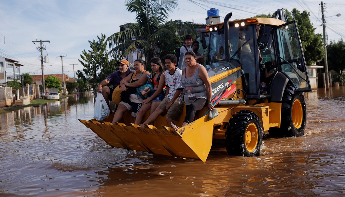 Pengungsi menaiki loader setelah rumah mereka terendam banjir di Eldorado do Sul, di Rio Grande do Sul, Brasil pada 7 Mei 2024. Foto: Reuters