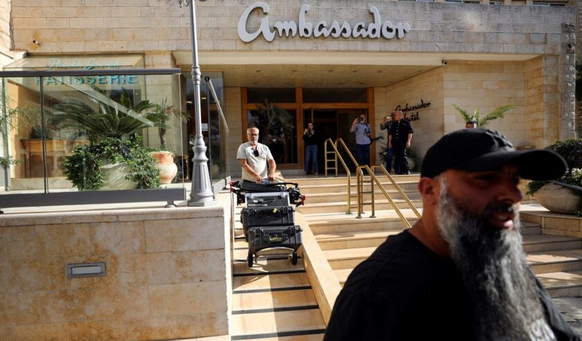 Seorang pria mengeluarkan peralatan media menyusul penggerebekan polisi Israel di kantor de facto Al Jazeera di Hotel Ambassador di Yerusalem pada 5 Mei 2024. Foto: Reuters