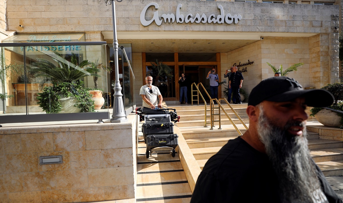 Seorang pria mengeluarkan peralatan media menyusul penggerebekan polisi Israel di kantor de facto Al Jazeera di Hotel Ambassador di Yerusalem pada 5 Mei 2024. Foto: Reuters