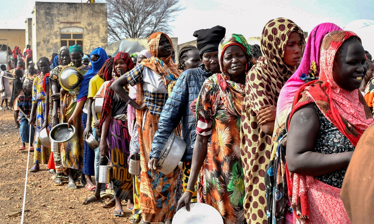 Para perempuan yang melarikan diri dari Sudan yang dilanda perang, mengantre untuk menerima jatah makanan di pusat transit Komisaris Tinggi PBB untuk Pengungsi (UNHCR) di Renk, Selatan Sudan. Foto: Reuters