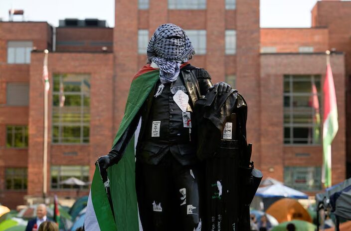 Patung George Washington yang diikat dengan bendera Palestina dan keffiyeh di dalam perkemahan pro-Palestina di Universitas George Washington di Washington, DC, AS. Foto: Reuters