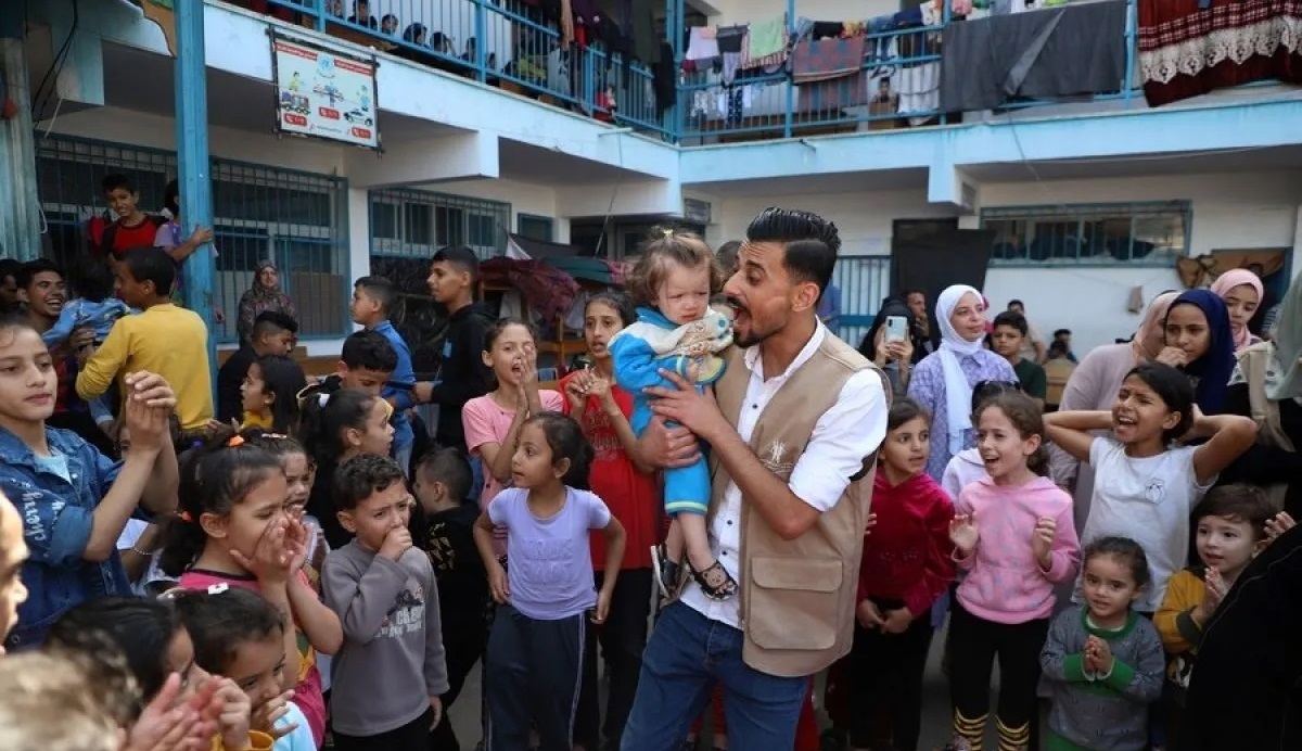 Seorang sukarelawan berinteraksi dengan anak-anak selama kegiatan stimulasi dan bantuan psikologis di sebuah sekolah yang berafiliasi dengan Badan Bantuan dan Pekerjaan PBB untuk Pengungsi Palestina (UNRWA) di kota Khan Younis, Jalur Gaza selatan, 8 November 2023. Foto: Antara