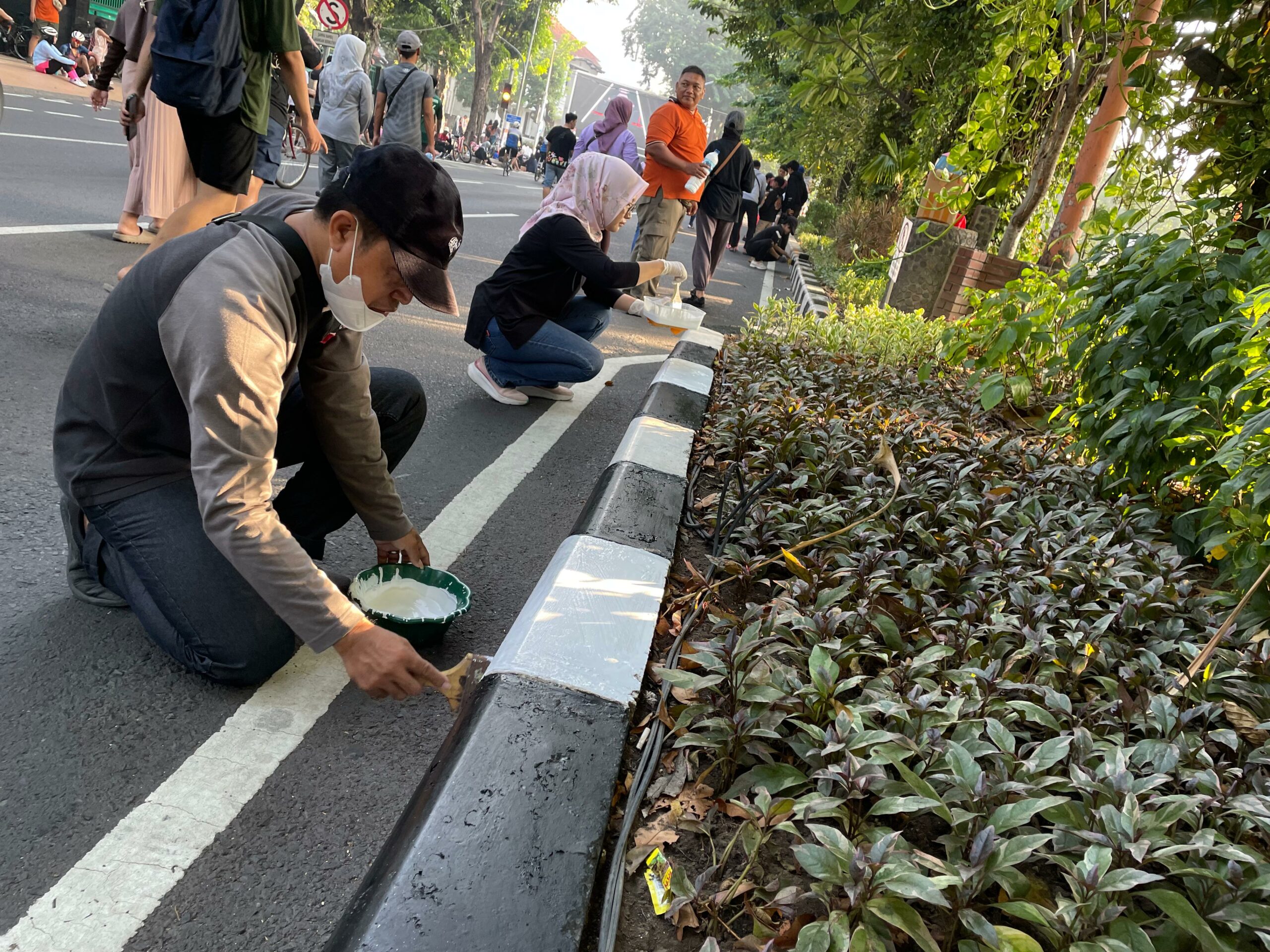 OPD Kecamatan Wonokromo saat mengecat curbing depan Taman Bungkul Surabaya, Minggu (12/5/2024). Foto: Firman magang suarasurabaya.net