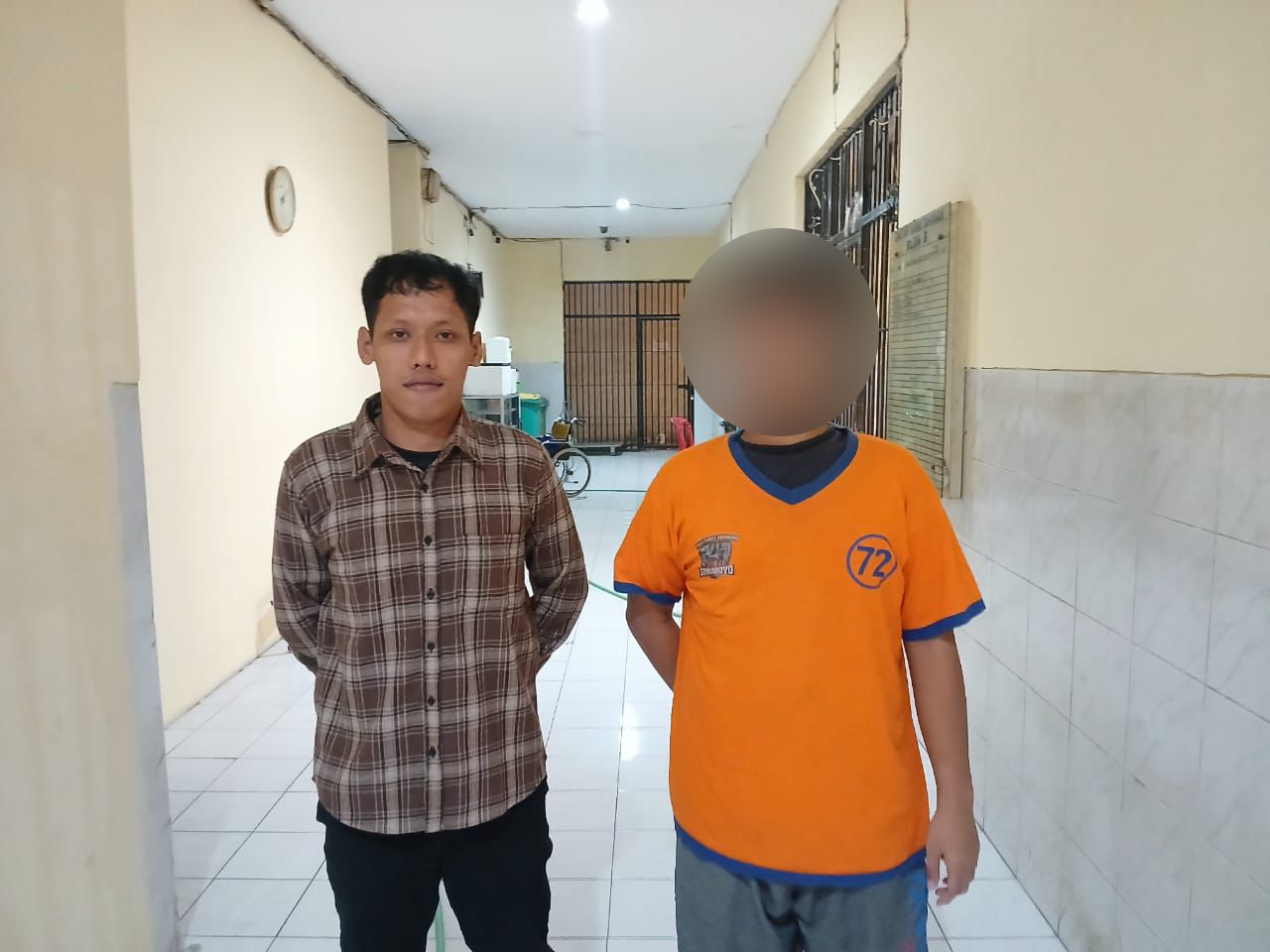 Salah satu tersangka pemerkosaan anak di bawah umur (kanan) bersama penyidik (kiri) diamankan kepolisian Polrestabes Surabaya, Senin (6/5/2024). Foto: Dok. Polrestabes Surabaya